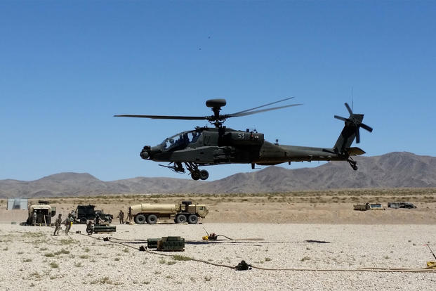 An AH-64E Apache helicopter takes off from its landing pad after arming and refueling during a rotation at the National Training Center in Fort Irwin, Calif. (US Army photo/Andrew Ruiz)