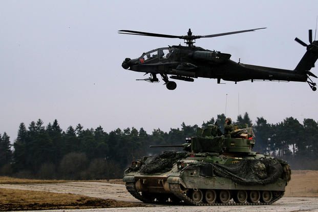 An M2 Bradley fighting vehicle and an AH-64 Apache helicopter secure an area during a Combined Arms Live Fire Exercise (CALFEX) in Grafenwoehr Training Area, Germany in March 2018. (US Army photo/Hubert Delany III)