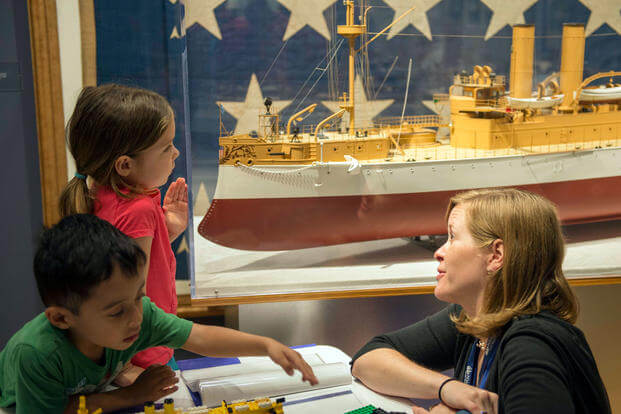Laura Orr, deputy education director at Hampton Roads Naval Museum, teaches children about the exhibits during the launch of the 2016 Blue Star Museums program. (U.S. Navy/Amy M. Ressler)