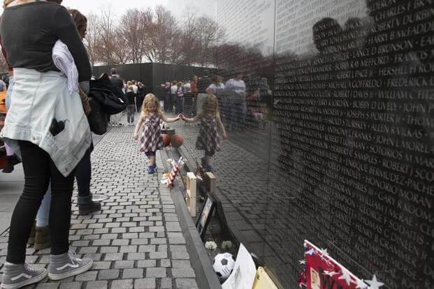 A young girl walks along the wall at the Vietnam War Memorial before a wreath laying ceremony in Washington, D.C., March 29, 2018. (U.S. Marine Corps/Cpl. Daisha R. Sosa)