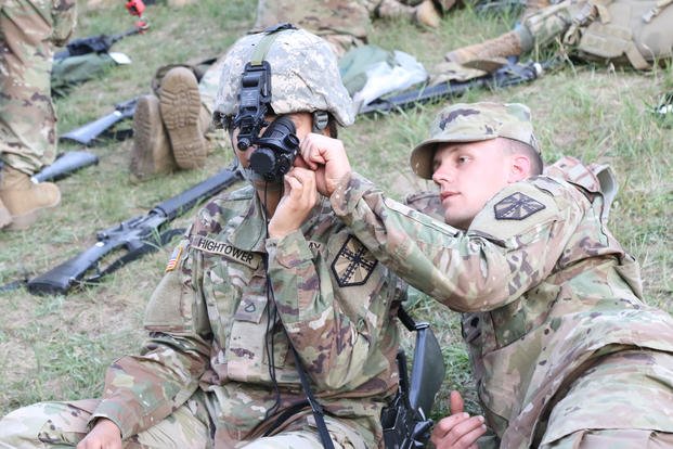 Spc. Collin A. Miller assists Pfc.l Lushell J. Hightower with adjusting Night Vision Goggles, Camp Grayling Joint Maneuver Training Center, June 9, 2018. (U.S. Army photo/Savannah Lang)