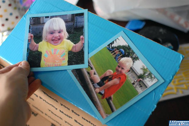 Place your photos on your Tape photos to your paper for your military birthday care package box. (Military.com)
