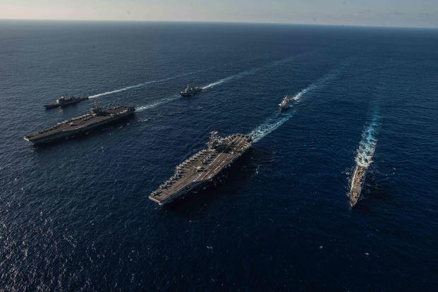 The aircraft carriers USS Ronald Reagan (CVN 76), left, and USS John C. Stennis (CVN 74) lead ships of their respective carrier strike groups as they transit the Philippine Sea during dual carrier operations, Nov. 16, 2018. (U.S. Navy photo/Kaila V. Peters)