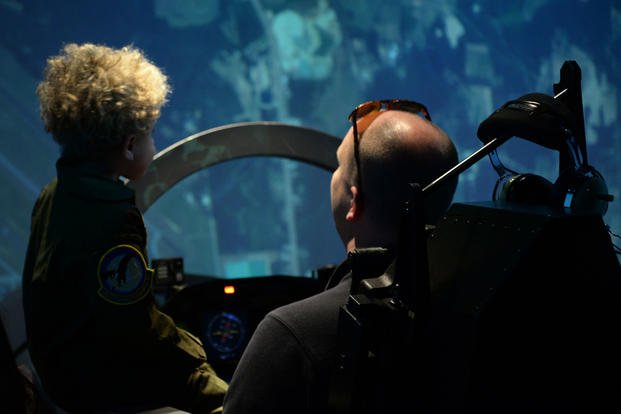 Tobias Taylor, Pilot for a Day, and Clay Taylor, Tobias’ father, try out a T-6 simulator at the 14th Operations Group, Dec. 6, 2018, on Columbus Air Force Base, Mississippi.  (U.S. Air Force/Hannah Bean)