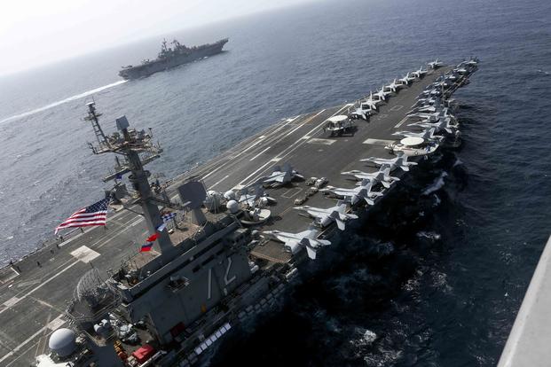 The USS Abraham Lincoln and the Assault Ship USS Kearsarge sail alongside as the Abraham Lincoln Carrier Strike Group and Kearsarge Amphibious Ready Group conduct operations in the U.S. 5th Fleet area of operations. (U.S. Navy/Mass Communication Specialist 1st Class Brian M. Wilbur)