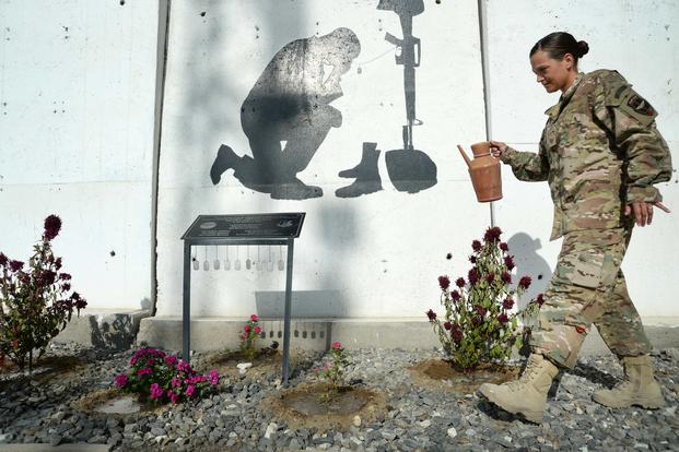 Air Force Tech. Sgt. Valarie waters the flowers around the NATO Air Training Command-Afghanistan (NATC-A) Nine Memorial at Forward Operating Base Oqab, Afghanistan, on Sept. 22, 2015. The 438th Air Expeditionary Advisor Group, with funds and donations by the Enlisted Coalition Council, built the NATC-A Nine Memorial in April 2013. (U.S. Air Force photo by Staff Sgt. Sandra Welch)