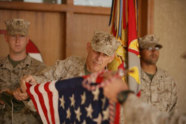 Maj. Gen. John F. Kelly, commanding general, Multi National Force-West, cases the colors signifying the transfer of MNF-West's headquarters to Al Asad Air Base. Kelly has ordered Camp Fallujah to close and handed back to the Iraqis in the next few months. More than 8,000 Marines from the camp have been relocated throughout the Anbar province or sent home. (Lindsay Sayres/U.S. Marine Corps)