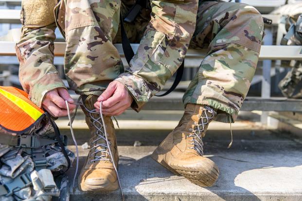 A U.S. Army Reserve Soldier ties his boots, preparing for a road march during the 335th Signal Command (Theater) Best Warrior Competition 2019 at Fort Gordon, Georgia, April 17, 2019. (U.S. Army Reserve/Staff Sgt. Leron Richards)