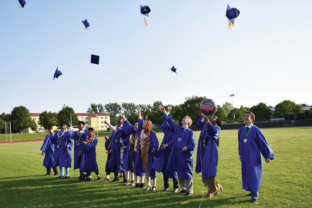 High school graduates toss caps.