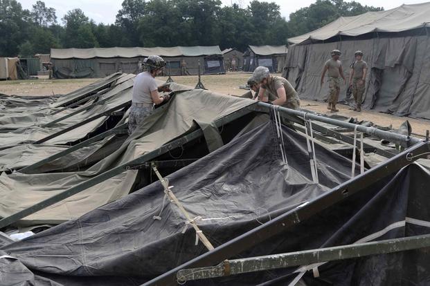 FILE PHOTO -- U.S. Army medical personnel under the 803rd Medical Center assemble a field hospital tent during the Combat Support Tactical Exercise in Fort McCoy, Wis., Aug. 12, 2019. (U.S. Army/Sgt. 1st Class Gary A. Witte, 207th Regional Support Group)