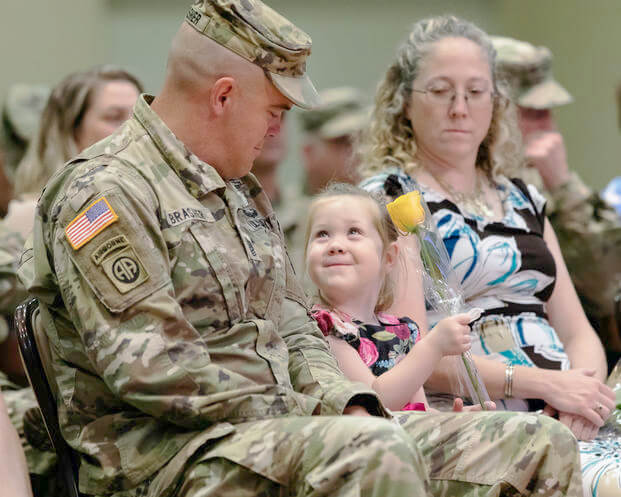 young daughter looking at her father during his change of command