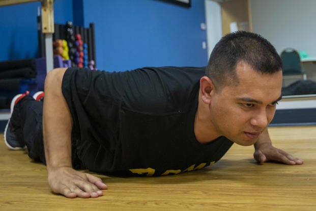 Sgt. Marc Morgenstern, 135th Mobile Public Affairs Detachment, Iowa Army National Guard, practices hand-release push-ups.