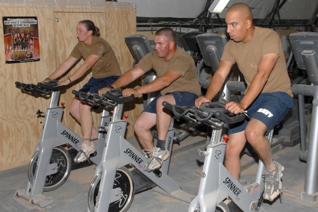 Navy Seabees ride stationary bikes in the gym at Camp Natasha, Afghanistan. 