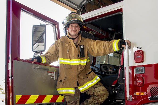 Senior Airman Cody Ferris steps down from the cab of a fire truck at Travis Air Force Base.