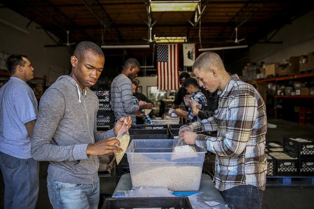 Marines and sailors pack bags of oatmeal during a volunteer event at The Angel's Depot in Vista, Calif.