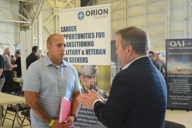 A service member listens to a hiring manager describe job openings during a Hiring Our Heroes event at Joint Base Lewis-McChord, Washington.