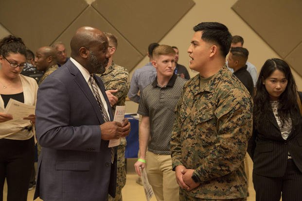 Retired U.S. Marine Corps Sergeant Major of the Marine Corps Ronald L. Green speaks with U.S. Marine Corps Cpl. Luis F. Garcia at the Hiring Our Heroes Career Summit at Camp Foster, Okinawa, Japan.