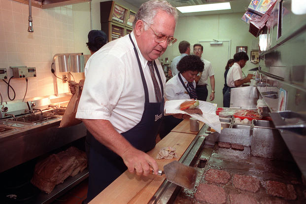 Dave Thomas, Wendy's restaurant founder and senior chairman of the board for Wendy's International Inc., flips hamburgers at one of the company's eateries in downtown Atlanta.
