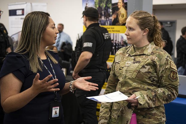 Leslee Guzman, BTS talent acquisitions, gives Senior Airmen Ashley Hogan information about career opportunities during the Hiring Our Heroes Job Fair at Wright-Patterson Air Force Base, Ohio.