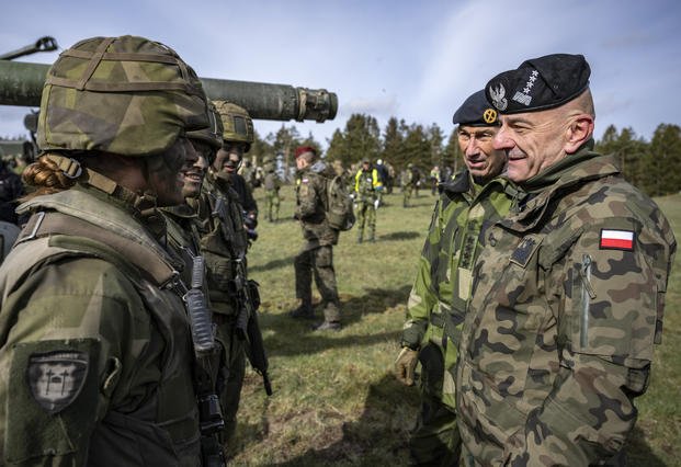  Poland's Chief of the General Staff, Gen. Rajmund Andrzejczak, right, talks to conscripted tank crews