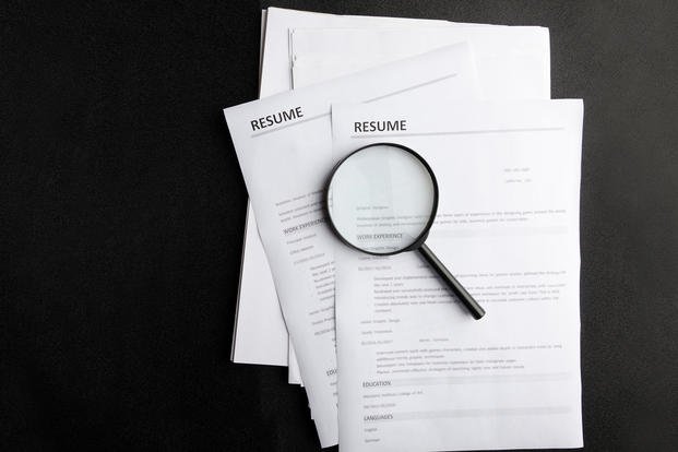 Magnifying glass on a resume.