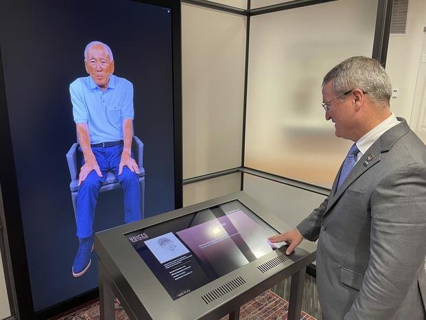 Peter Crean of the National WWII Museum in New Orleans stands at an interactive exhibit