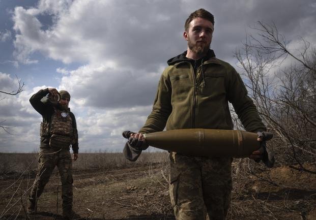 Ukrainian soldiers carry shells to fire at Russian positions 