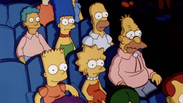 The Simpsons sitting in a theater, image taken from official Fox/Disney trailer. The Simpsons sitting in a theater, image taken from official Fox/Disney trailer.