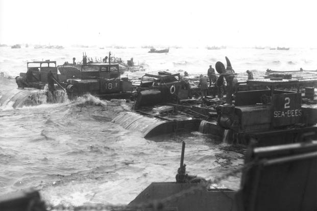 Three Rhino barges and a petrol barge are being hammered by surf somewhere along the coast of France. (Photo: U.S. Army)