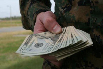 Soldier holds a stack of cash.