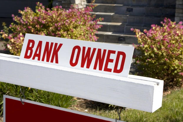 bank owned sign next to house