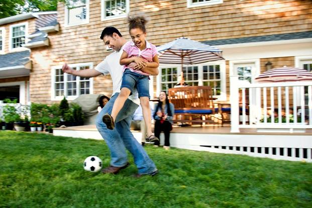 family playing soccer on lawn