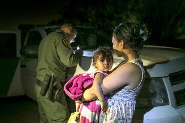 Flor Garcia, 19, of Honduras, holding her one-year-old daughter, Flor Fernandez, turned themselves over to Customs and Border Protection Services agents after crossing the Rio Grande. (AP Photo/Austin American-Statesman, Rodolfo Gonzalez)