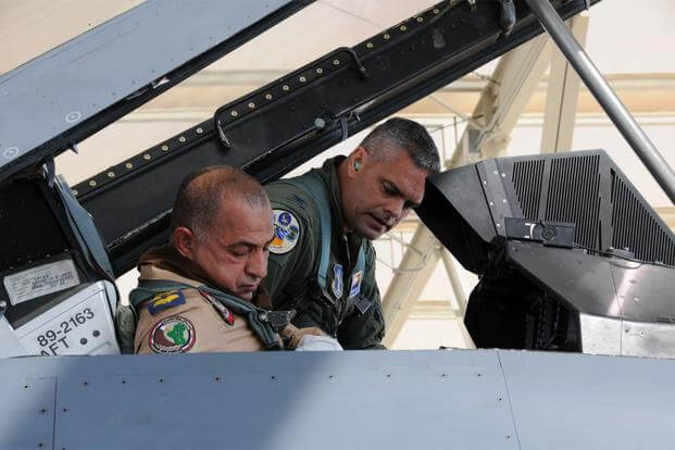 FILE -- Col. Andrew MacDonald helps Iraqi Air Force Brig. Gen. Abdulhussein Lafta Ali Ali buckle into an F-16D Fighting Falcon at Tucson International Airport Aug. 30, 2012 (U.S. Air Force/Maj. Gabe Johnson)
