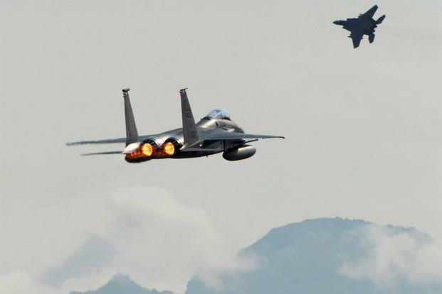 A pair of F-15C Eagles from the 18th Wing at Kadena Air Base, in Japan, take off from Joint Base Elmendorf-Richardson near Anchorage, Alaska, June 23, 2015, while participating in Northern Edge. (Bill Roth/Alaska Dispatch News via AP)