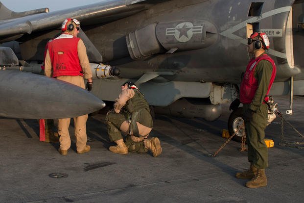 Marines, attached to the 26th Marine Expeditionary Unit (MEU), perform last minute checks of an AV-8B Harrier. Photo by Mass Communication Specialist Seaman Tyler Preston