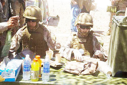 Ryan Forbes, right, a 13-year-old San Diego native diagnosed with Medulloblastoma, a form of brain cancer, and his older brother Jason eat “chow” with the Marines of Lima Battery, 3rd Battalion, 11th Marine Regiment, 1st Marine Division.