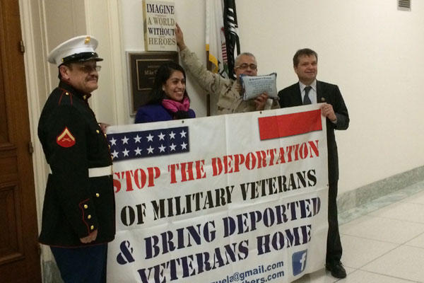 Marine Vietnam veteran Manuel Valenzuela holds up protest banner with, from left, Susana Sandoval of Dream Moms USA, former Petty  Officer 3rd Class Esteban Burgoa and Rep. Mike Quigley, D-Illinois, outside Quigley’s office on Jan. 6.