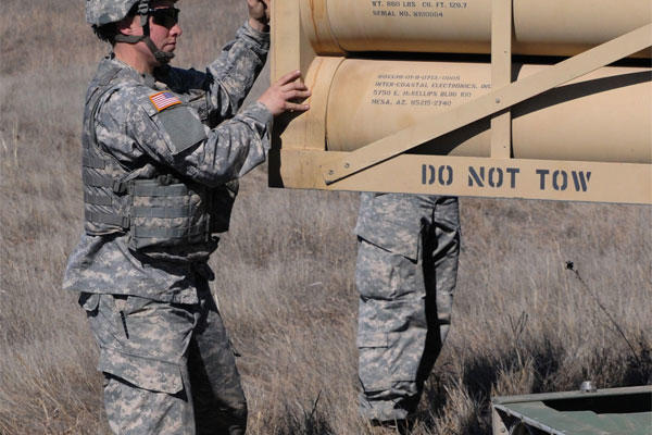 Army Cpl. Erica Gunter, a launcher chief in A Battery, 2nd Battalion, 4th Field Artillery at Fort Sill, Okla., works with her launcher crew to reload its M270A Multiple Launch Rocket System. (U.S. Army photo by Sgt. Joe Dees)