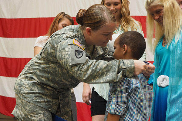 New York Army National Guard Staff Sgt. Marlana Watson presents her New York State Medal for Valor, to her son, Lassan Green.(U.S. Army/Sgt. J.P. Lawrence)