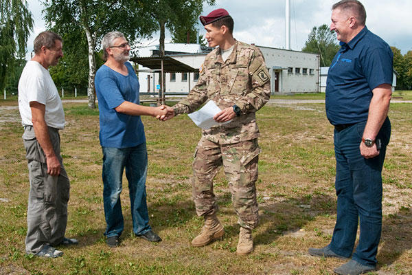U.S. Army Pfc. Aidarbek Raev talks with military contractors about a construction project in Lithuania. Raev, a native of Bishkek, Kyrgyzstan, is fluent in Russian, the second-most common language in Lithuania. (U.S. Army/Sgt. Jarred Woods)