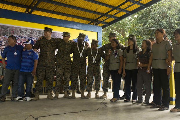 Marines and the teachers and staff of Concepcion Elementary School sing together during an intermission at the ribbon cutting ceremony Oct. 8, during Amphibious Landing Exercise 2015. (Photo By: Lance Cpl. Robert D. Williams Jr)
