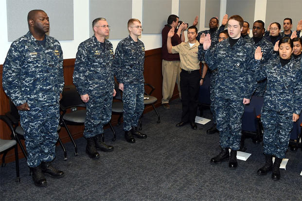Rear Adm. Stephen C. Evans (left), commander, NSTC, and Capt. W. David Pfeifle, commanding officer, Recruit Training Command (RTC), observe 18 recruits and Sailors take the Oath of Citizenship during a naturalization ceremony. (Photo: Scott A. Thornbloom)