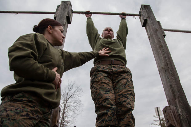 Major Misty Posey, left, assists a Marine doing pull-ups at Marine Corps Base Quantico, Virginia, Feb. 19, 2016. (Photo: Sgt. Dylan Bowyer)