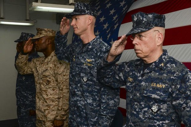 Participants render salutes during the national anthem as part of a change of command ceremony aboard the amphibious assault ship USS Boxer (LHD 4). (Photo: Mass Communication Specialist 3rd Class Michael T. Eckelbecker)