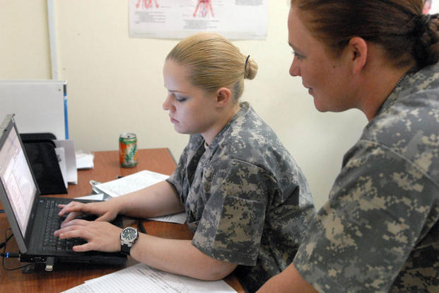 Pfc. Dominka Jakubczak (left), of Yuma, N.M., enters data into a computer system, Sept. 24 2009, after screening patients at the Hale Koa Medical Facility with help from Spc. Anna Hatfield, from Conroe, Texas. (Photo: Pfc. Bailey Jester)