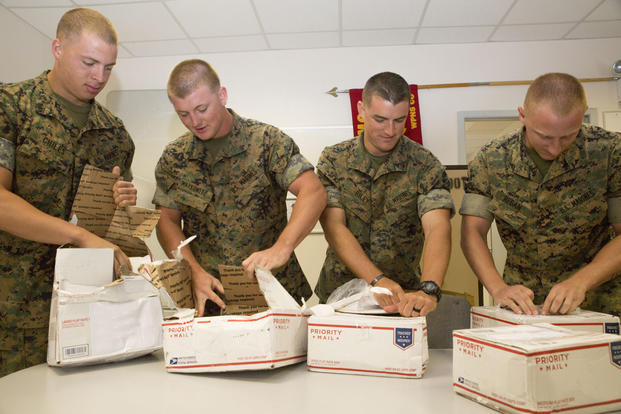 U.S. Marines with Black Sea Rotational Force 16.2 open care packages containing a variety of snack and hygiene items at Mihail Kogălniceanu Air Base, Romania, Aug. 23, 2016. (U.S. Marine Corps photo illustration by Sgt. Kirstin Merrimarahajara)