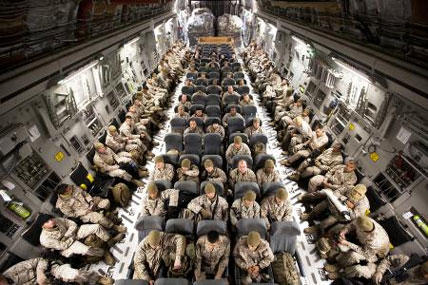 Marines and sit aboard an Air Force C-17 transport aircraft on the flight line at Marine Corps Base Hawaii before departing for Camp Dwyer, Afghanistan, on Oct. 30. (Photo by Cpl. Reece Lodder/Marine Corps)