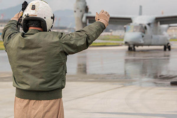 Staff Sgt. David Hoyt guides a MV-22B Osprey into place for air-delivery ground refueling training. (Cpl. Carlos Cruz Jr./U.S. Marine Corps)