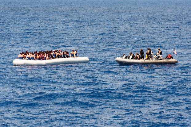 Sailors assigned to the USS Carney approach a small craft full of migrants while on patrol in the Mediterranean Sea on July 29, 2016. Senior Chief Personnel Specialist Galen Draper/Navy